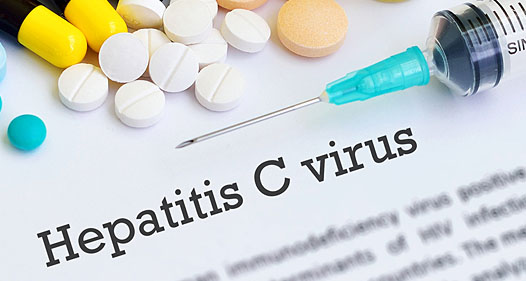 Needle and pills on top of a piece paper reading "Hepatitis C virus."